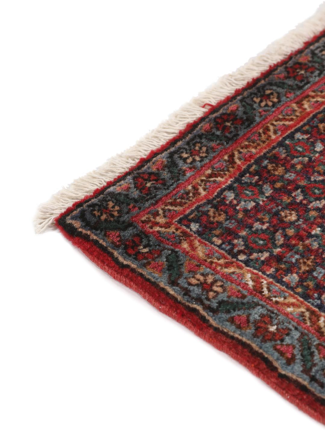 Ein handgeknüpfter Senneh Wolle-Teppich aus dem Mittleren Osten mit einem dunkelroten und blauen Medaillon-Muster.