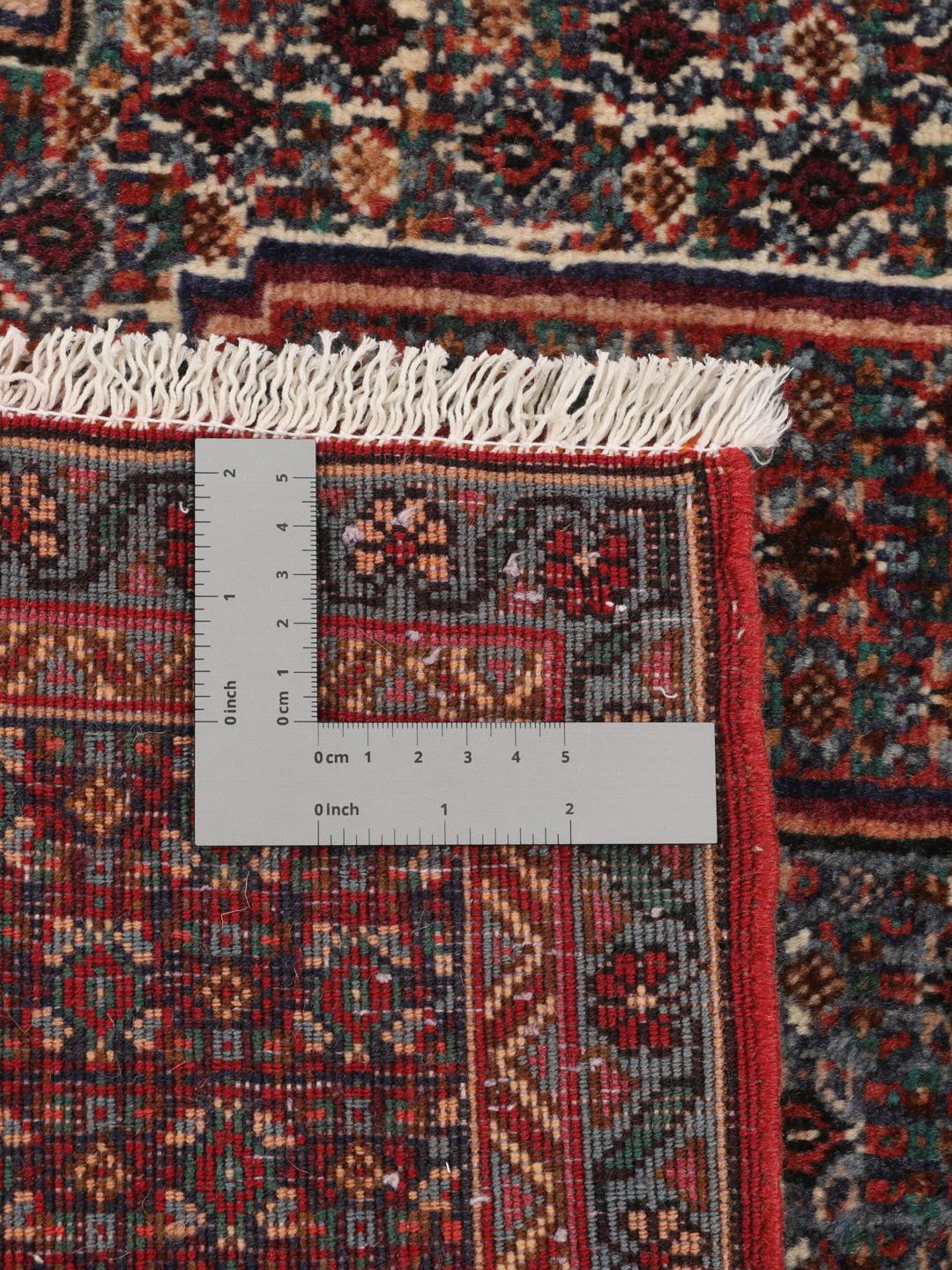 Ein handgeknüpfter Senneh Wolle-Teppich aus dem Mittleren Osten mit einem dunkelroten und blauen Medaillon-Muster.