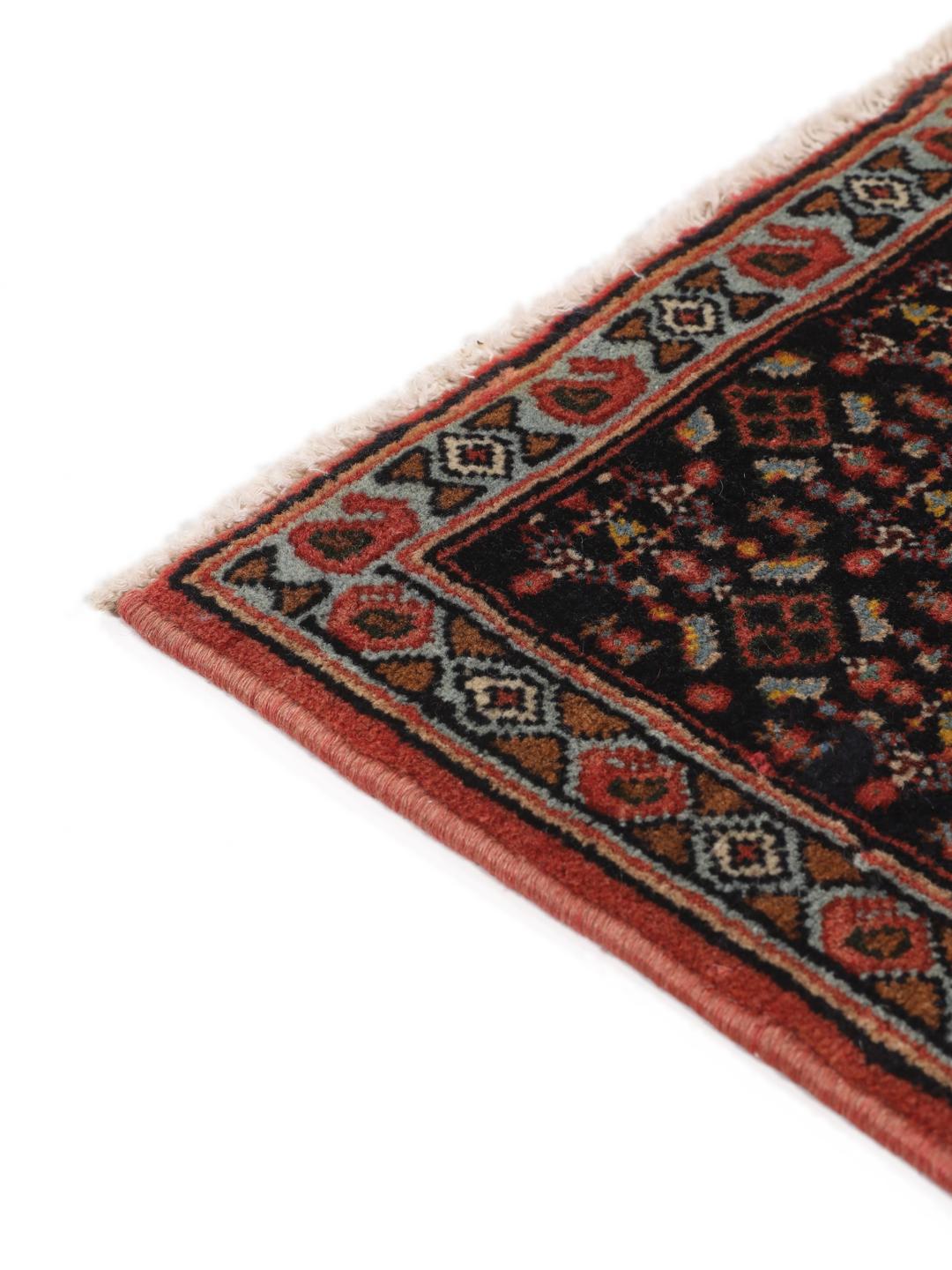 Hand-knotted Senneh rug from the Middle East in red and black