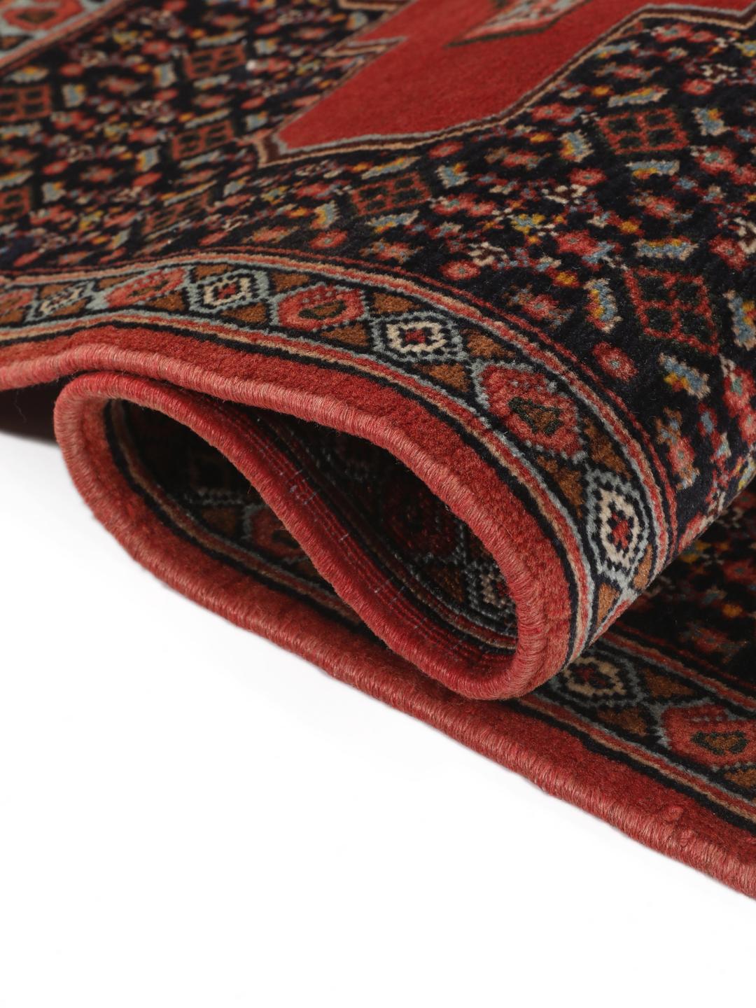 Hand-knotted Senneh rug from the Middle East in red and black
