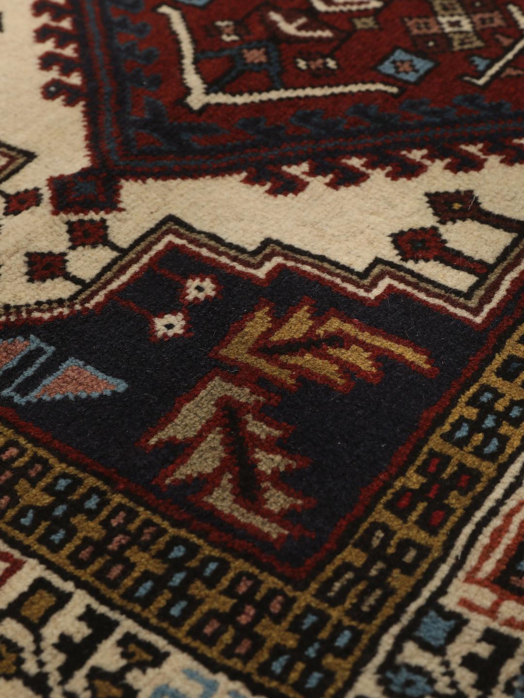 Een handgeknoopte Ardebil loper met donkerrode en beige geometrische patronen uit het Midden-Oosten.