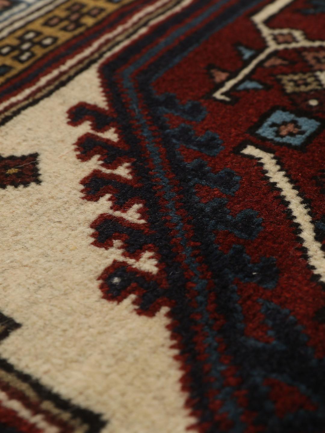 Een handgeknoopte Ardebil loper met donkerrode en beige geometrische patronen uit het Midden-Oosten.