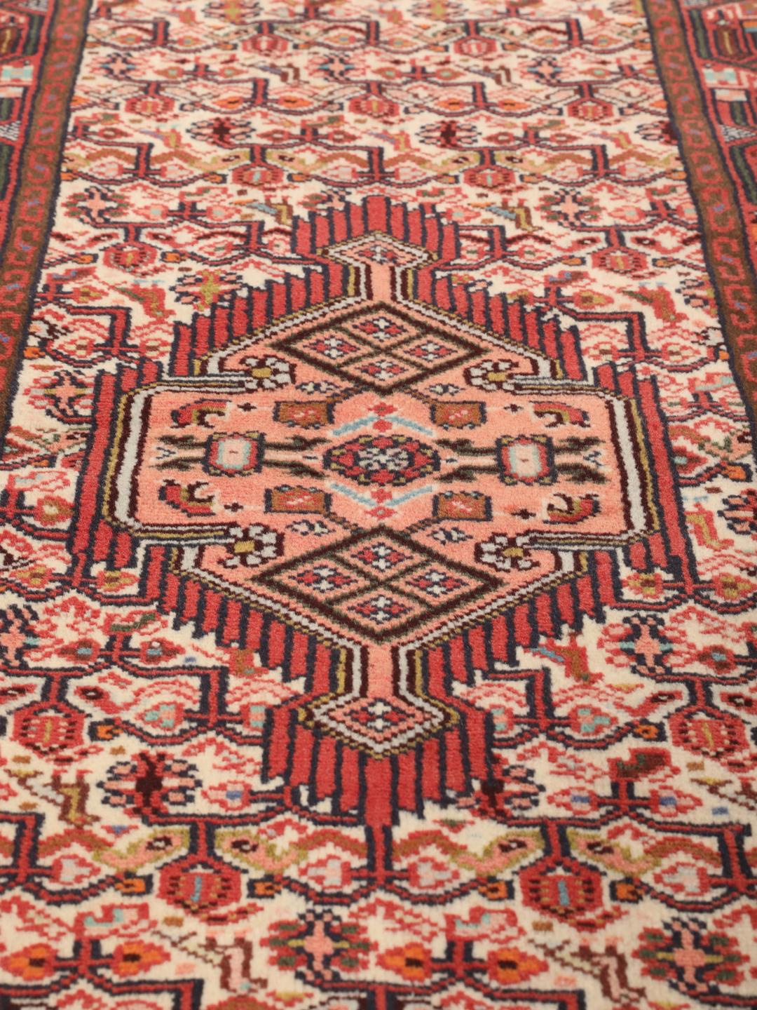 Handgeknoopte Asadabad loper met traditionele geometrische motieven in rood en crème