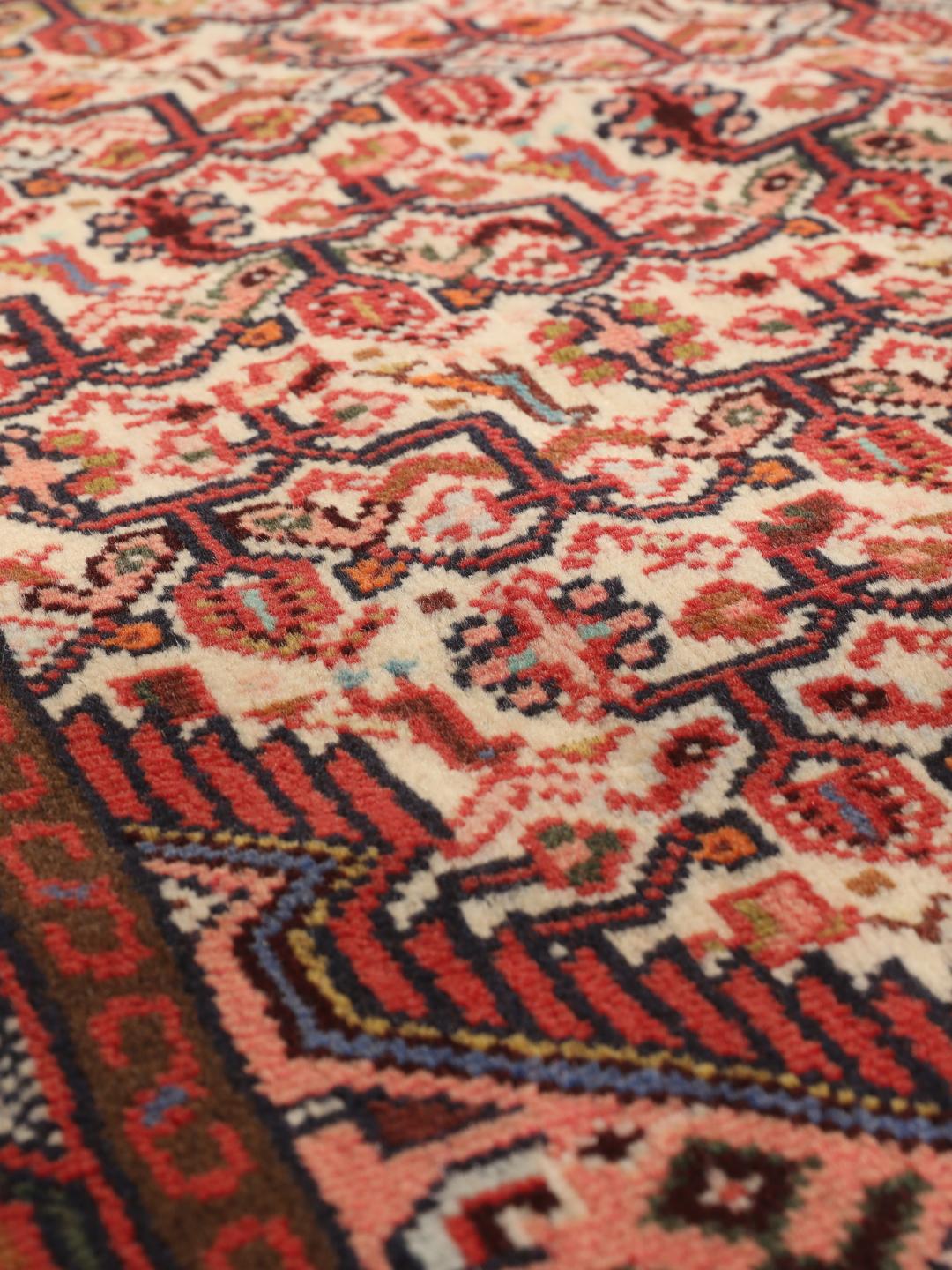 Handgeknoopte Asadabad loper met traditionele geometrische motieven in rood en crème