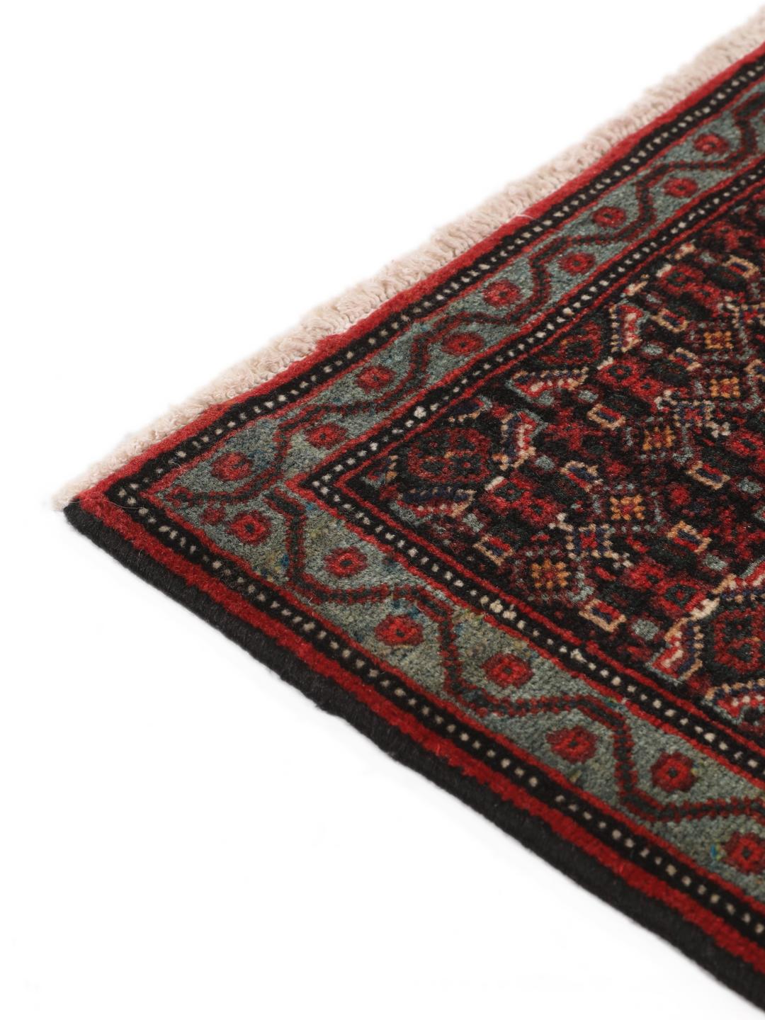 A hand-knotted Senneh rug from the Middle East in dark-red and dark-blue tones.