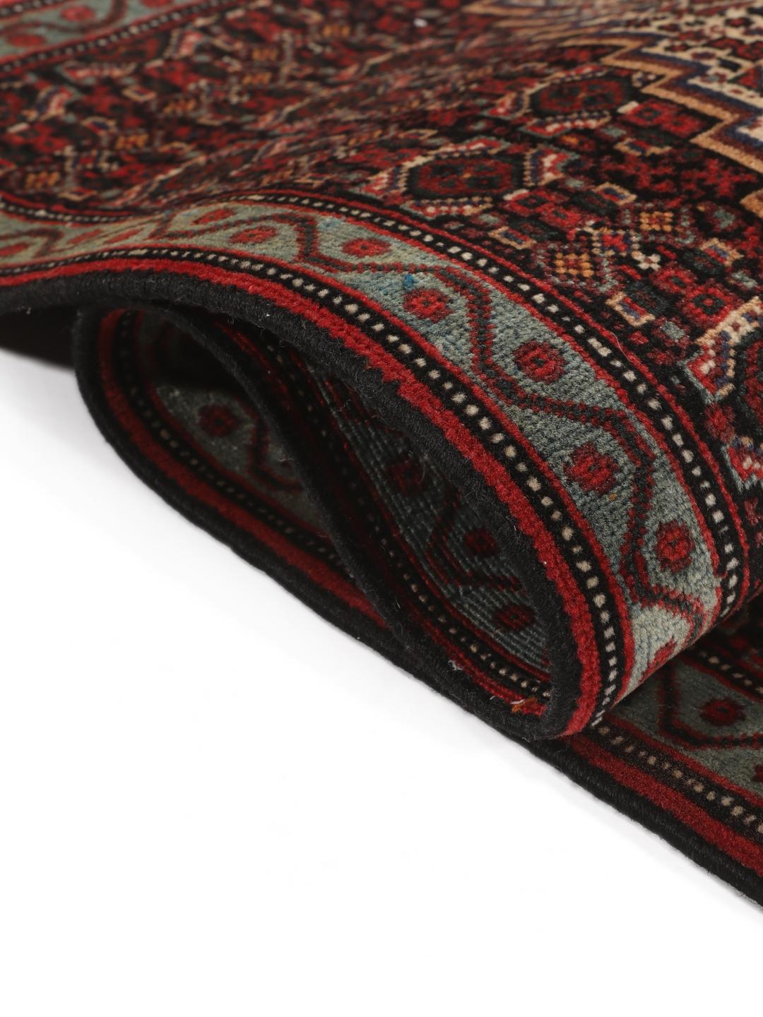 A hand-knotted Senneh rug from the Middle East in dark-red and dark-blue tones.