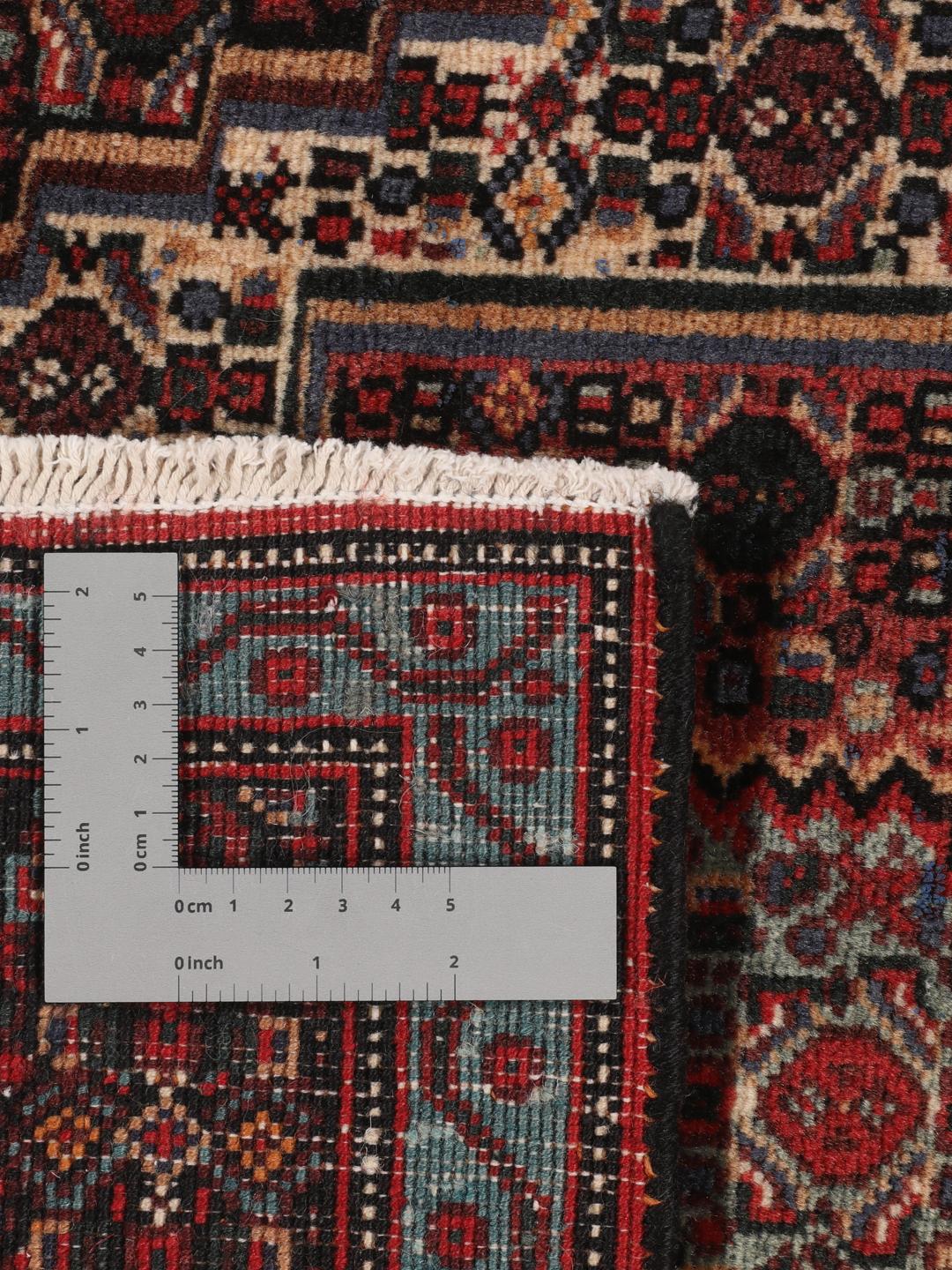 A hand-knotted Senneh rug from the Middle East in dark-red and dark-blue tones.