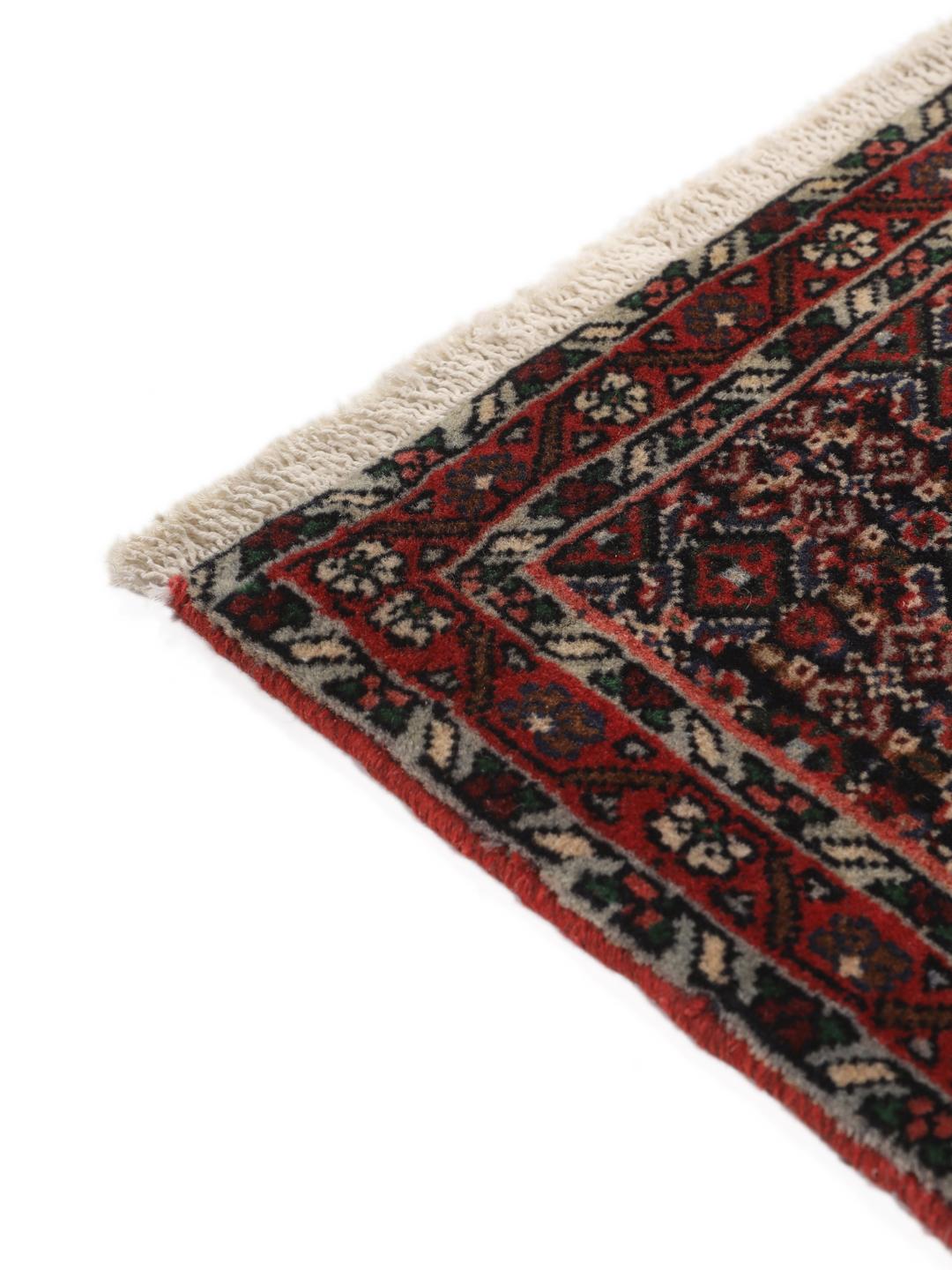 Hand-knotted Senneh wool rug in red with intricate geometric medallion patterns