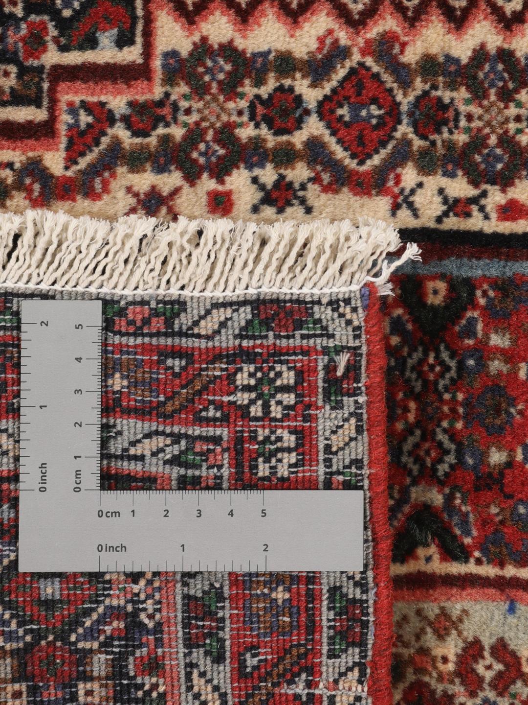 Hand-knotted Senneh wool rug in red with intricate geometric medallion patterns