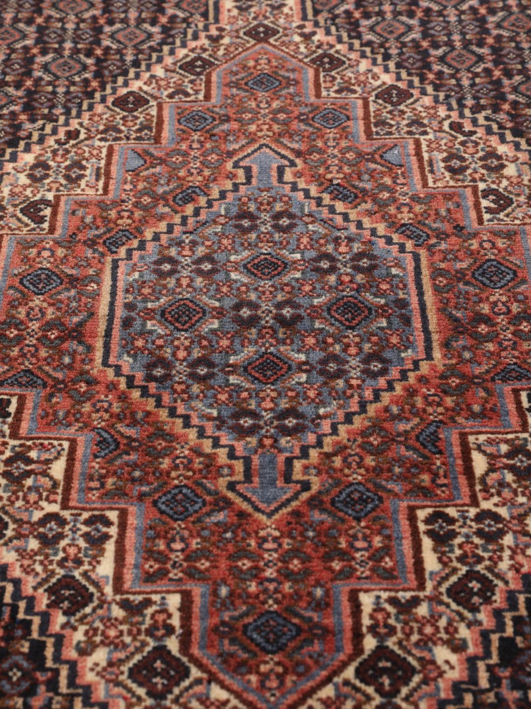 A hand-knotted Senneh rug from the Middle East in dark-blue and dark-red tones.