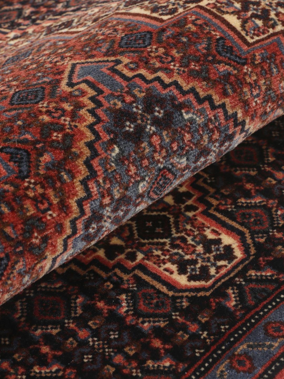A hand-knotted Senneh rug from the Middle East in dark-blue and dark-red tones.
