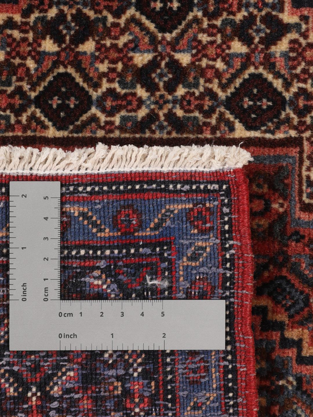 A hand-knotted Senneh rug from the Middle East in dark-blue and dark-red tones.