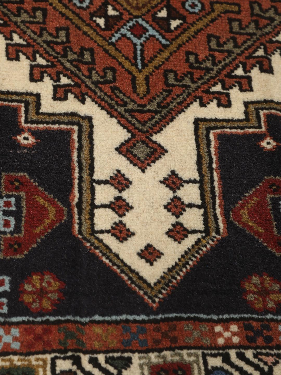 En håndknyttet Ardebil-løber fra Mellemøsten med et geometrisk design i flere farver.