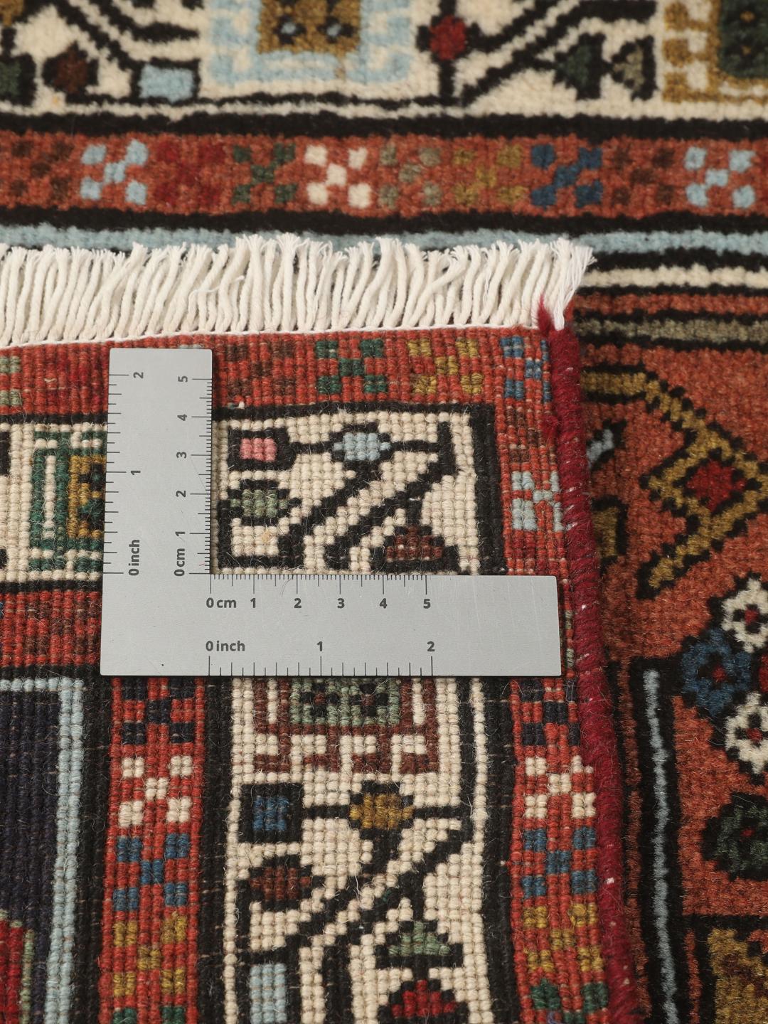 En håndknyttet Ardebil-løber fra Mellemøsten med et geometrisk design i flere farver.