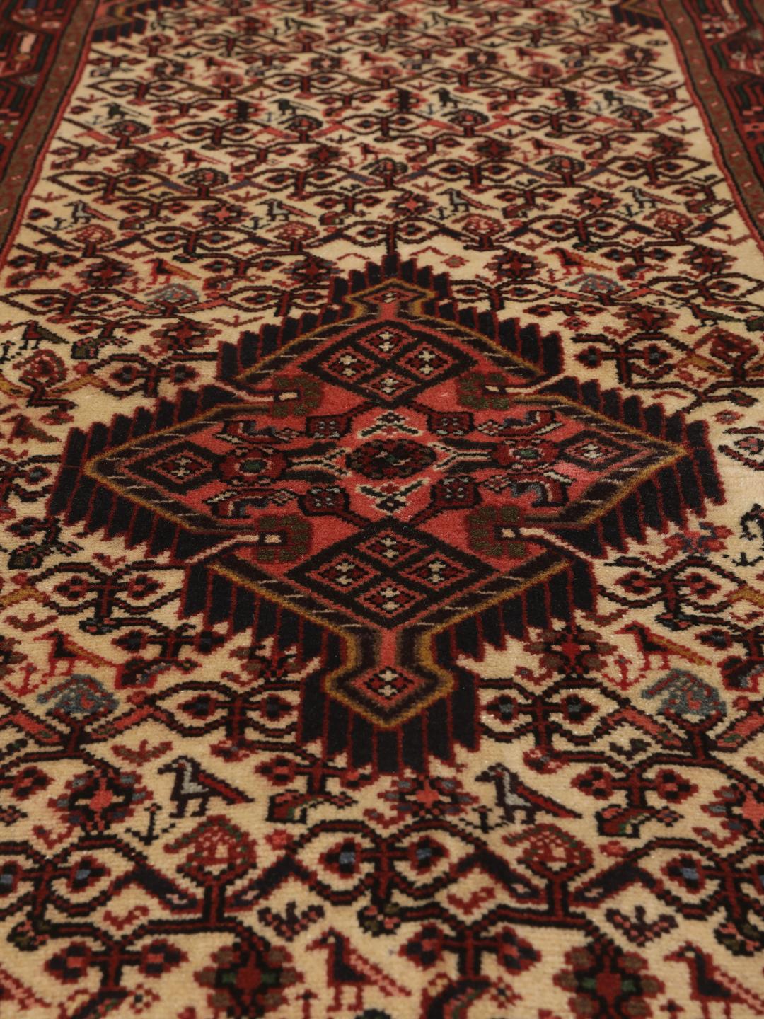 Een handgeknoopte Asadabad loper uit het Midden-Oosten met een rood en beige geometrisch patroon.