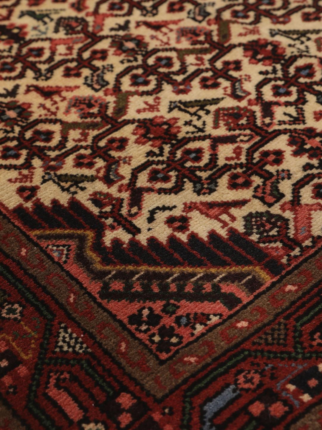 Een handgeknoopte Asadabad loper uit het Midden-Oosten met een rood en beige geometrisch patroon.