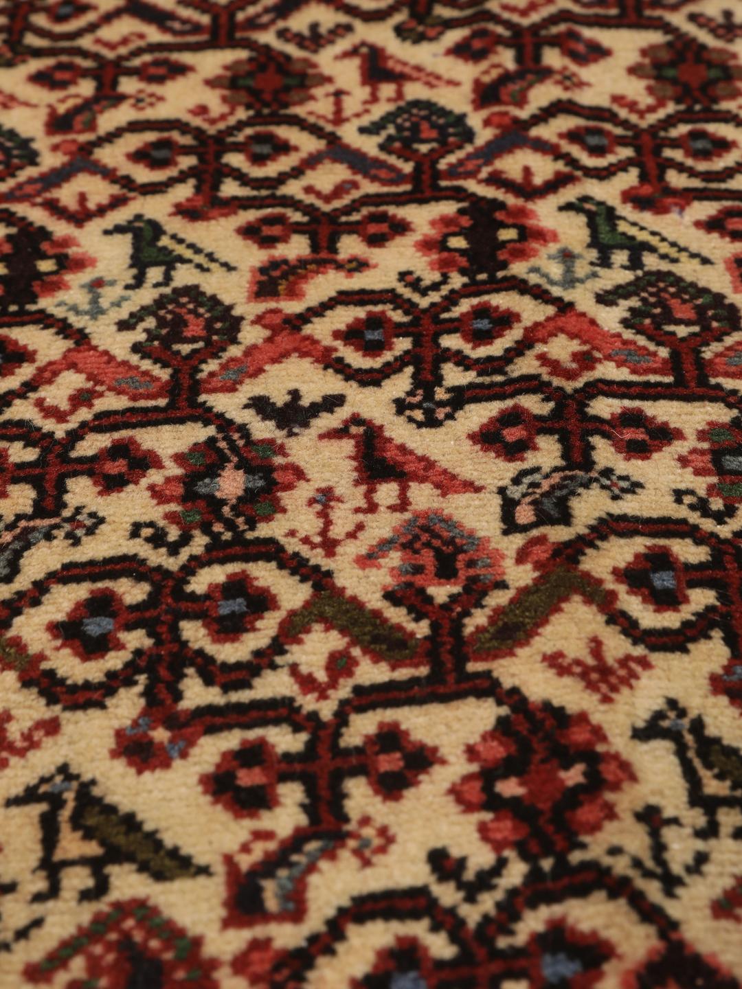 Een handgeknoopte Asadabad loper uit het Midden-Oosten met een rood en beige geometrisch patroon.