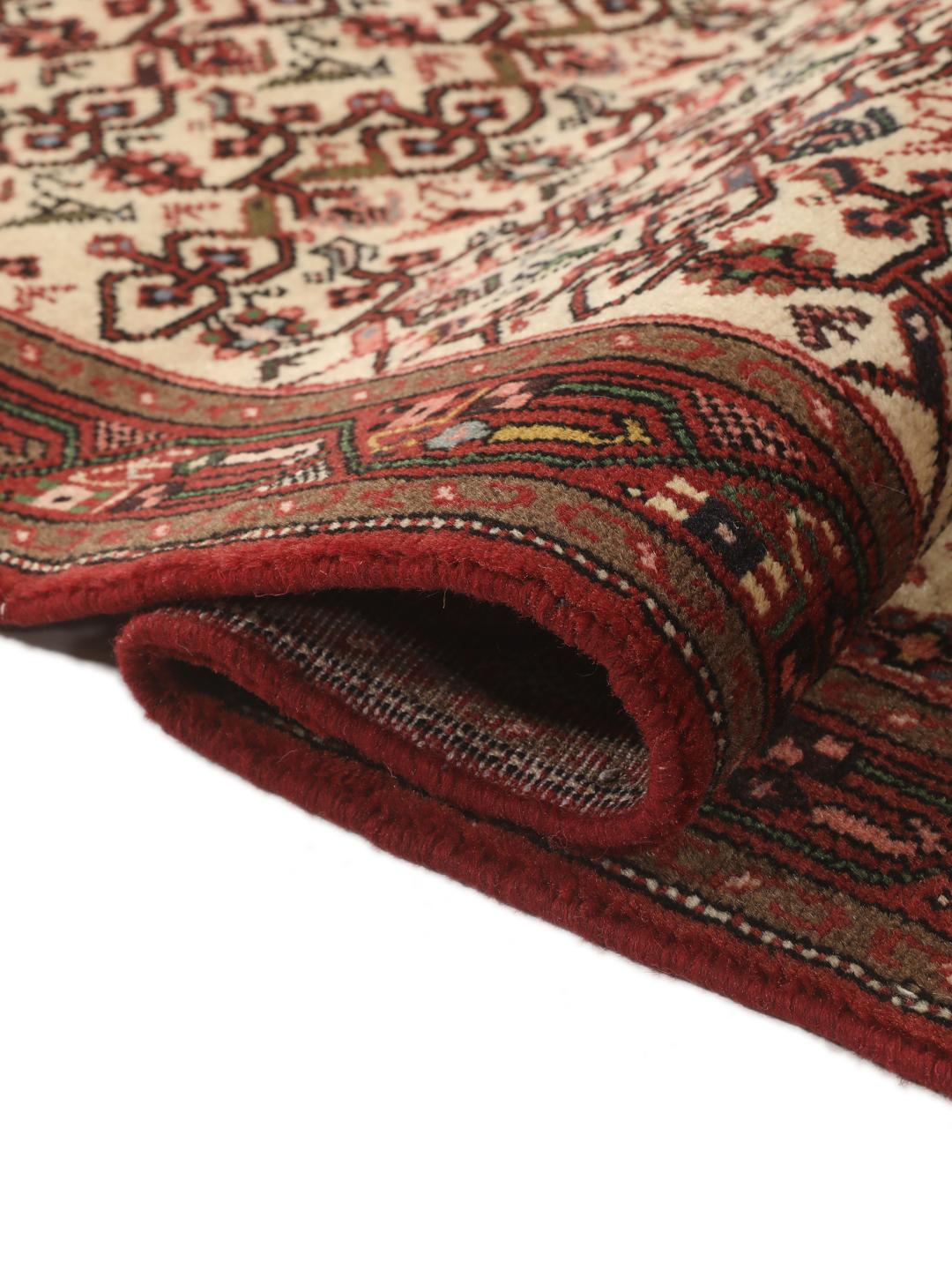 Een handgeknoopte Asadabad loper uit het Midden-Oosten met een rood en beige geometrisch patroon.