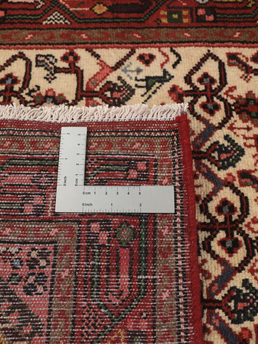 Een handgeknoopte Asadabad loper uit het Midden-Oosten met een rood en beige geometrisch patroon.