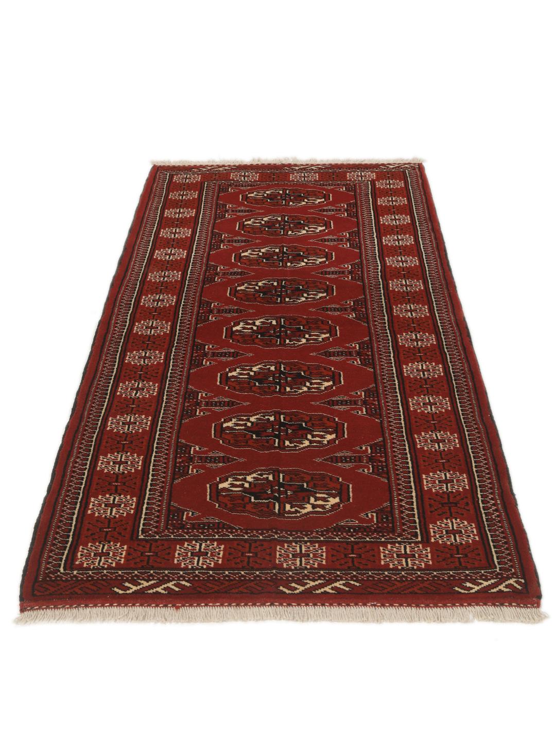 A hand-knotted Middle Eastern Turkaman runner in deep red with geometric medallion patterns.