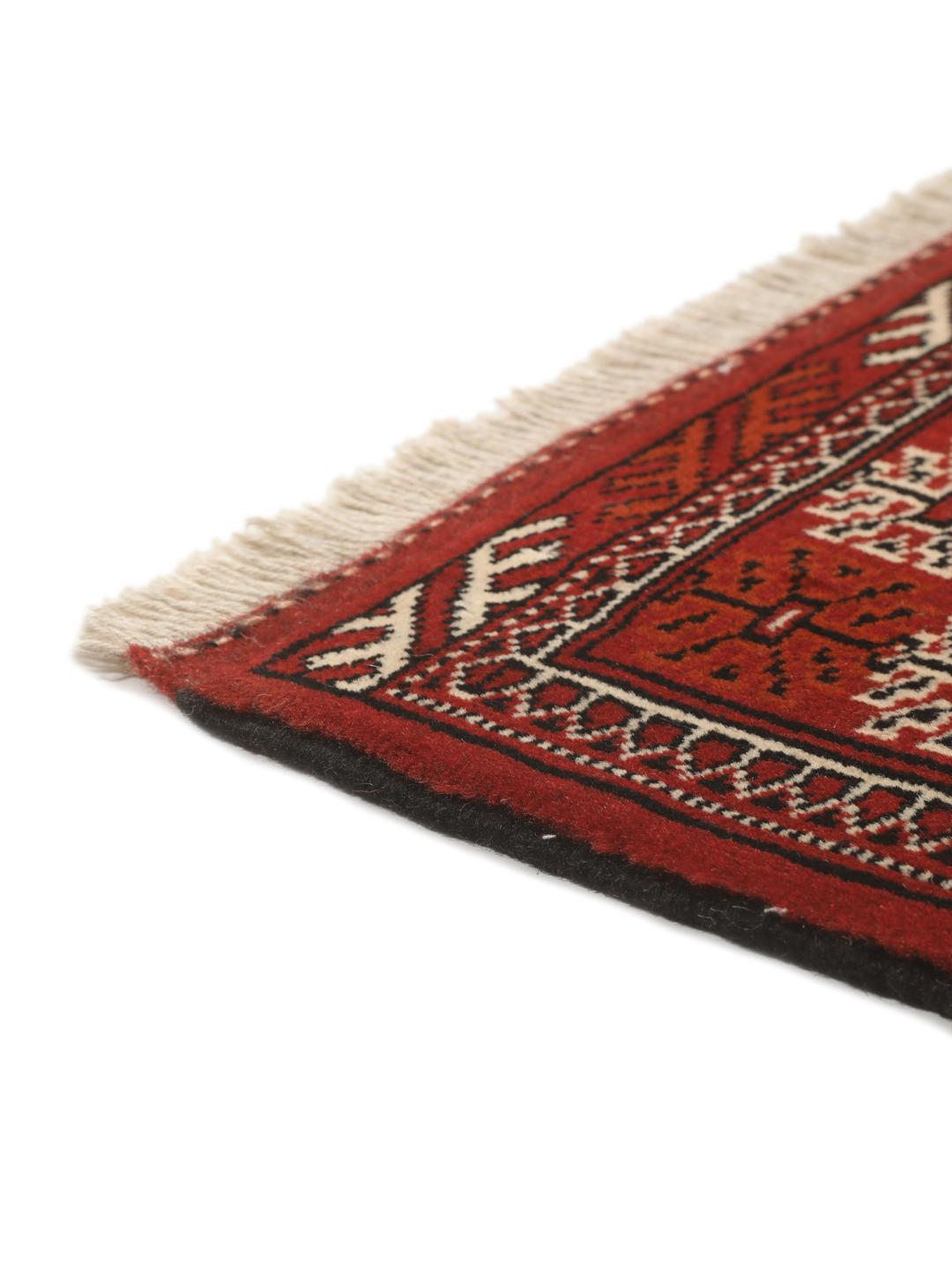 A hand-knotted Middle Eastern Turkaman runner in deep red with geometric medallion patterns.