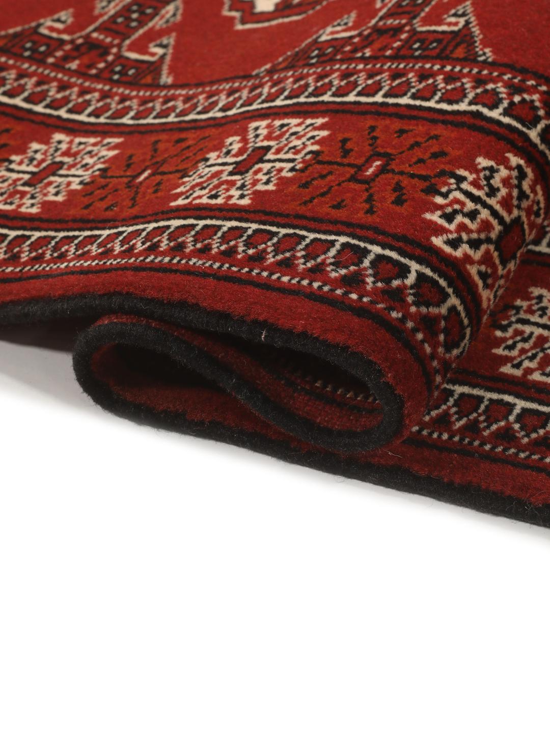 A hand-knotted Middle Eastern Turkaman runner in deep red with geometric medallion patterns.