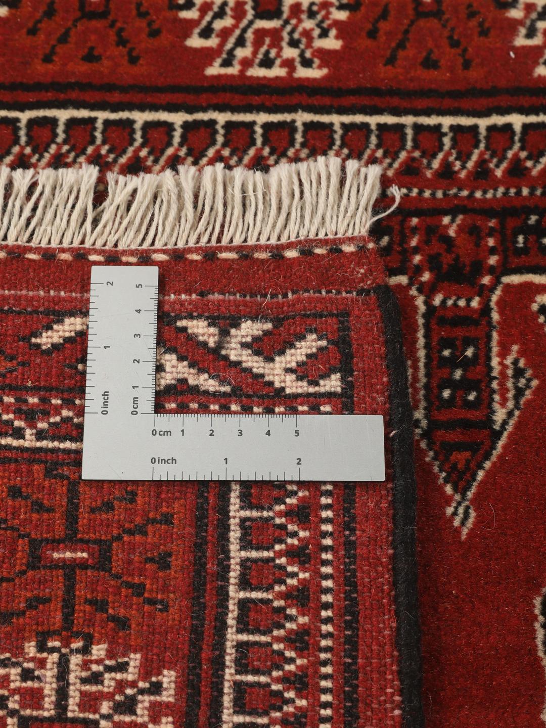 A hand-knotted Middle Eastern Turkaman runner in deep red with geometric medallion patterns.
