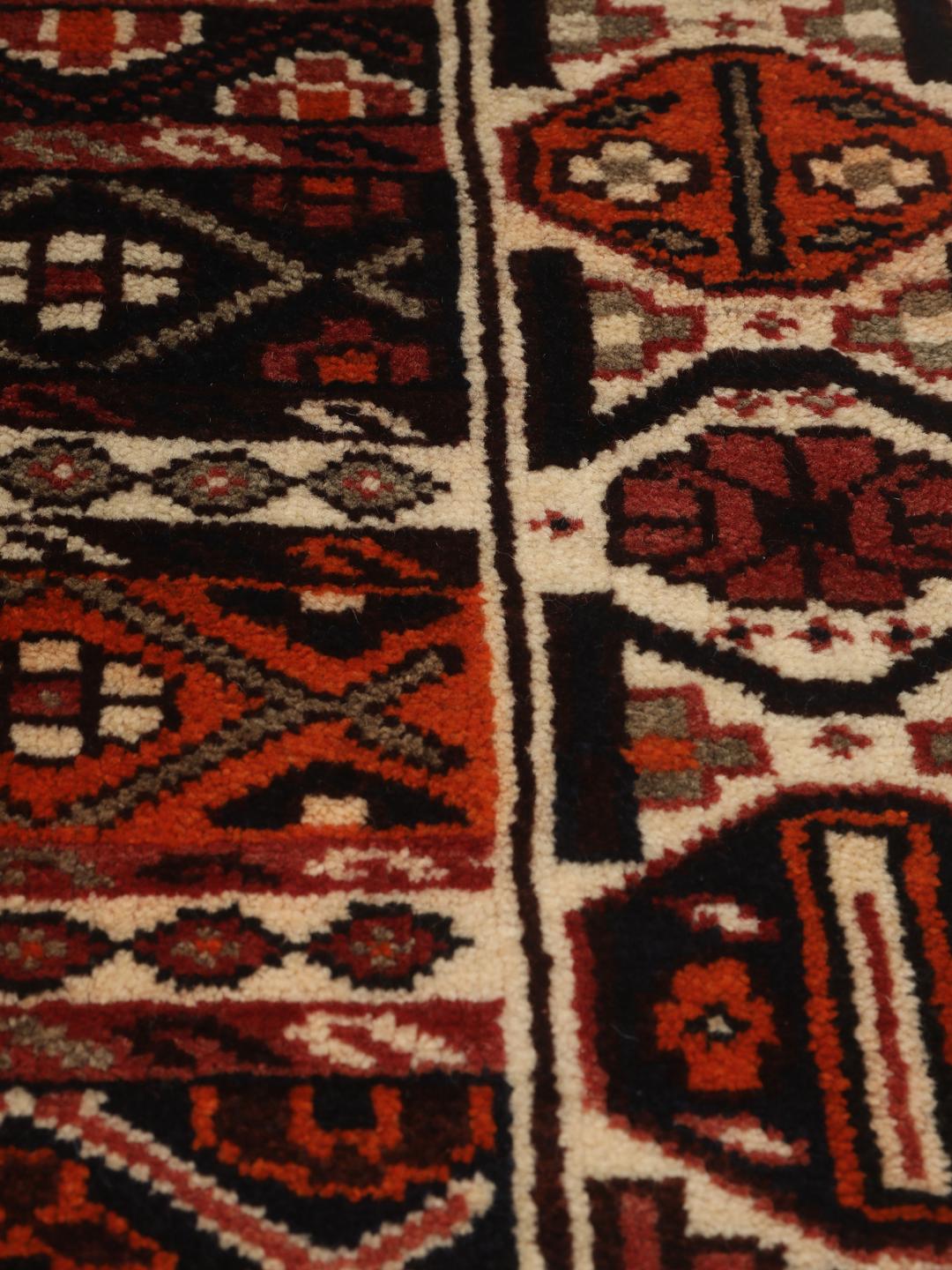 Hand-knotted Shiraz rug from the Middle East featuring a red and black geometric design