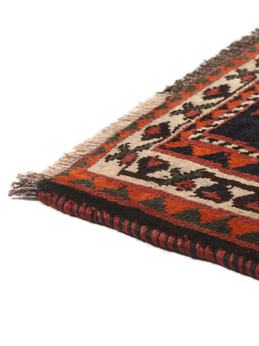 Een rechthoekig handgeknoopt Ghashghai tapijt uit het Midden-Oosten met een donkerrood en donkerblauw palet met geometrische motieven.