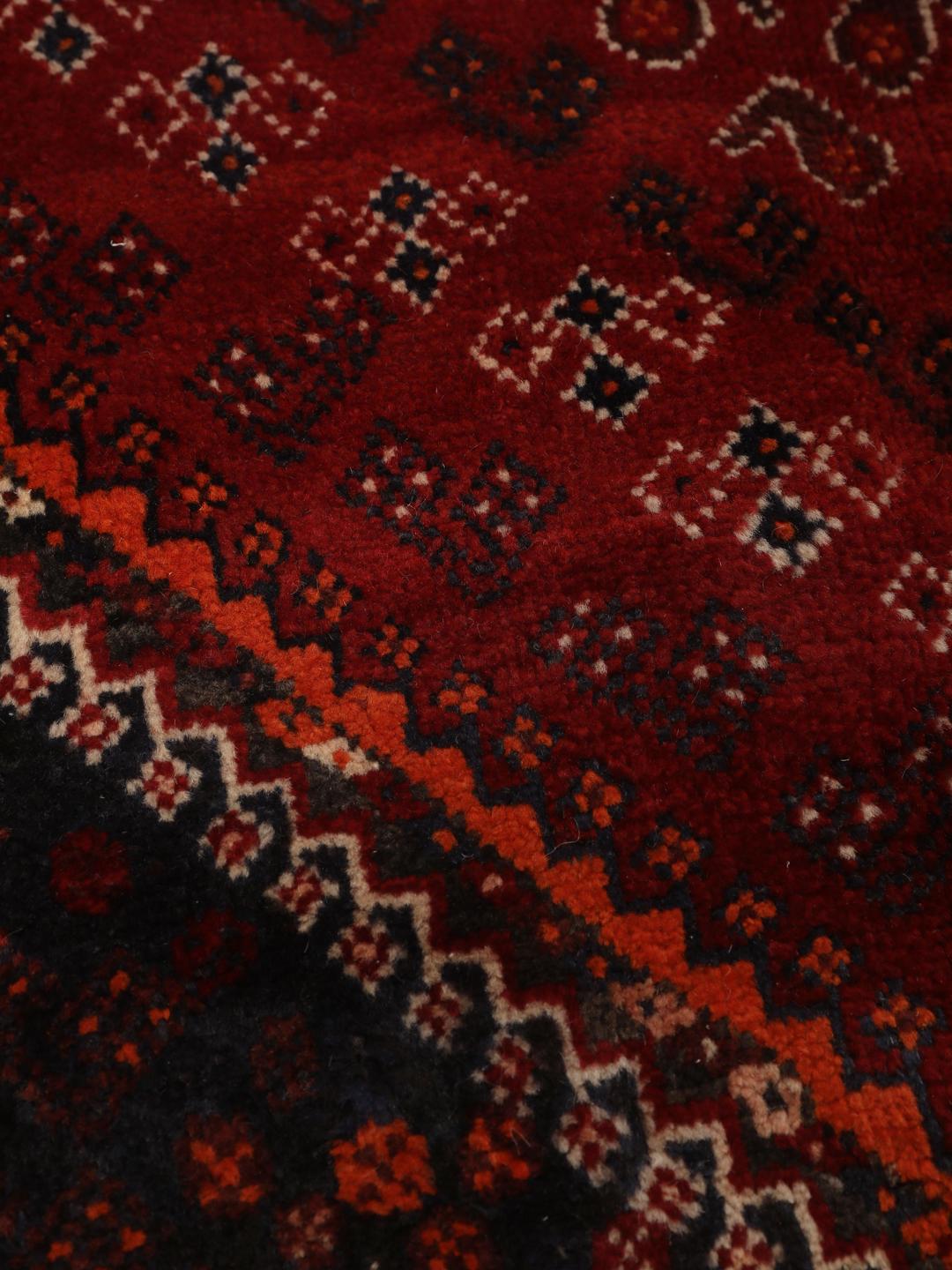 Hand-knotted Qashqai rug from the Middle East with a red field and geometric patterns