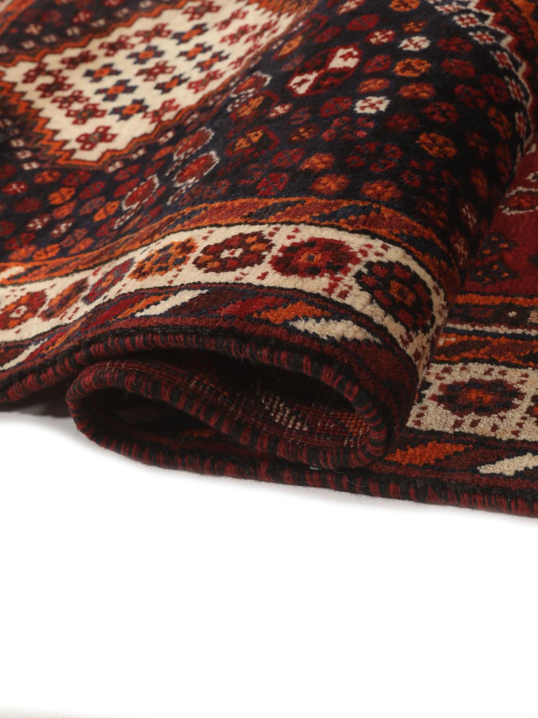 Hand-knotted Qashqai rug from the Middle East with a red field and geometric patterns