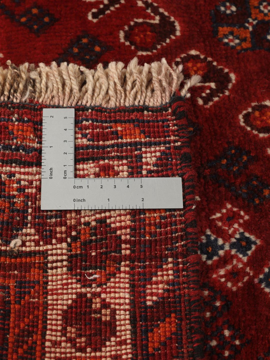 Hand-knotted Qashqai rug from the Middle East with a red field and geometric patterns