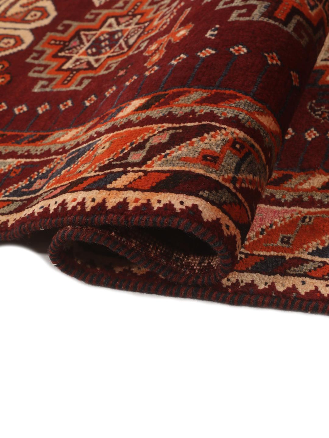 Hand-knotted Qashqai rug from the Middle East featuring geometric patterns in dark red and multicolour wool.