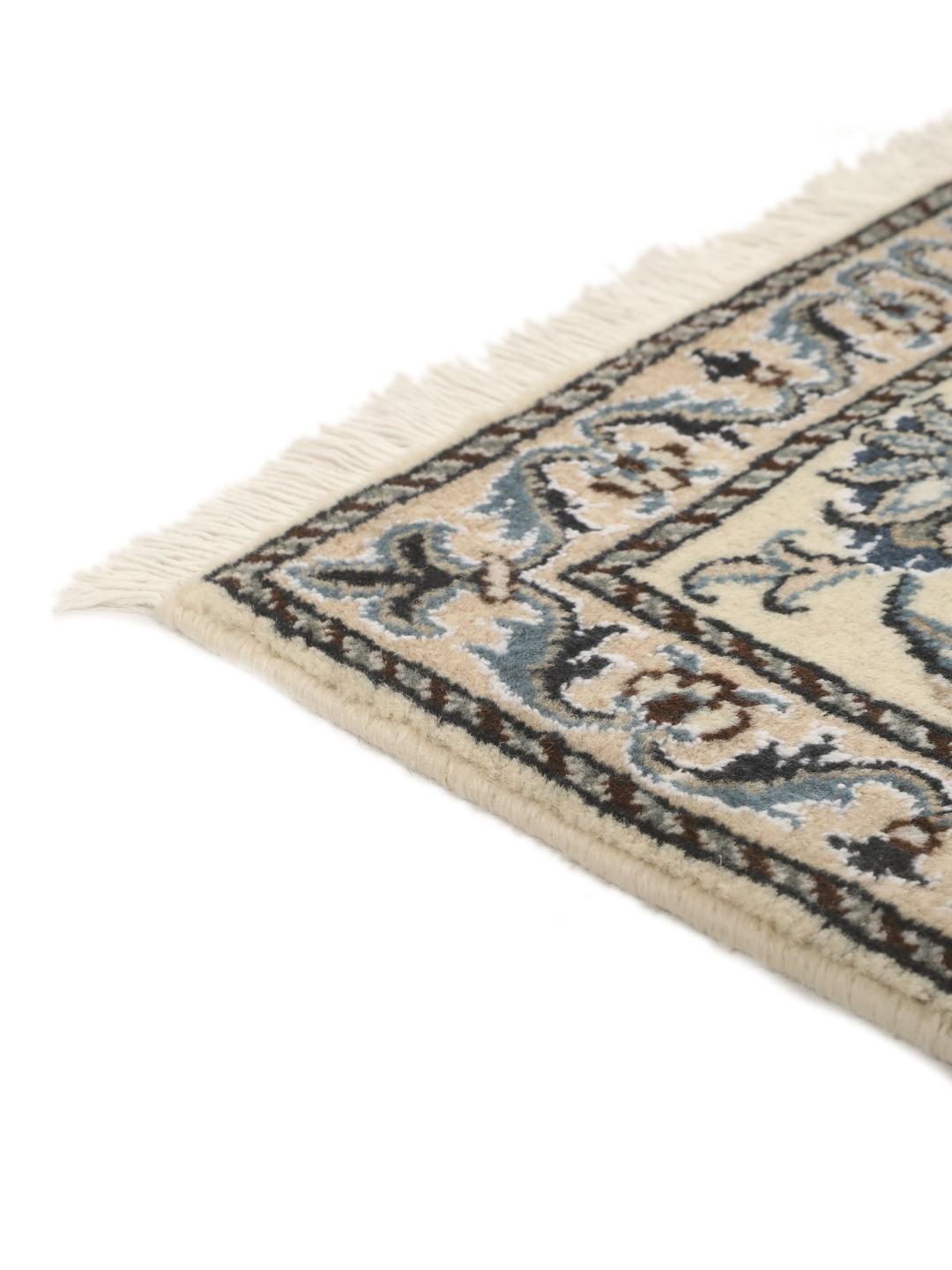 Hand-knotted Nain rug from the Middle East with a light beige field and blue floral motifs