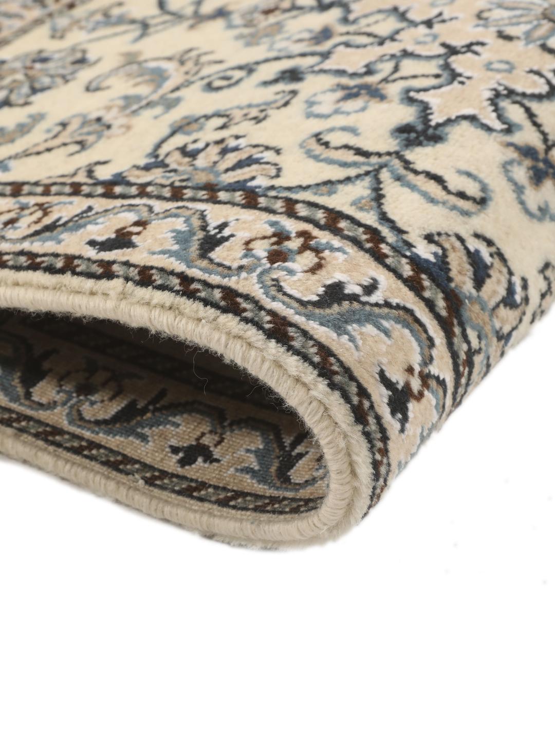 Hand-knotted Nain rug from the Middle East with a light beige field and blue floral motifs