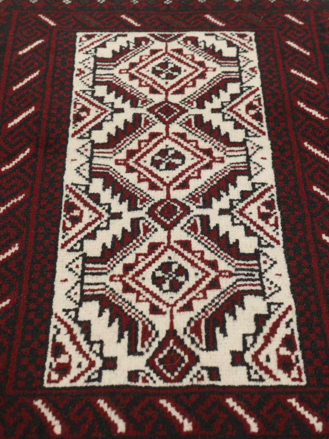Ein handgeknüpfter Beluch-Teppich aus dem Mittleren Osten mit einem dunkelroten und beigen geometrischen Design.