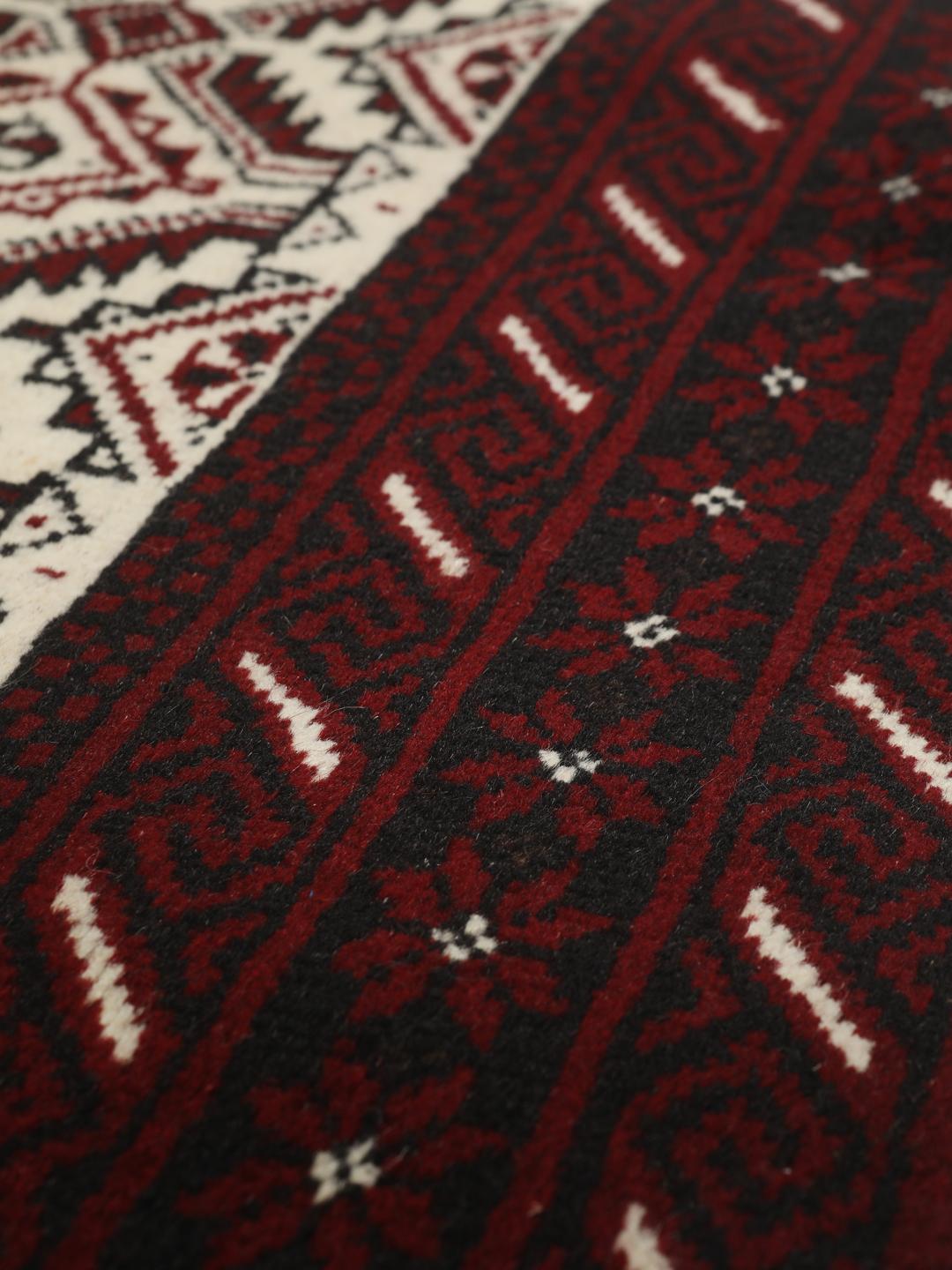 Ein handgeknüpfter Beluch-Teppich aus dem Mittleren Osten mit einem dunkelroten und beigen geometrischen Design.