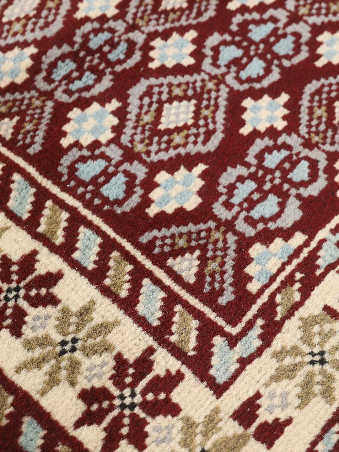 Hand-knotted Beluch rug with geometric motifs in red, blue, and cream