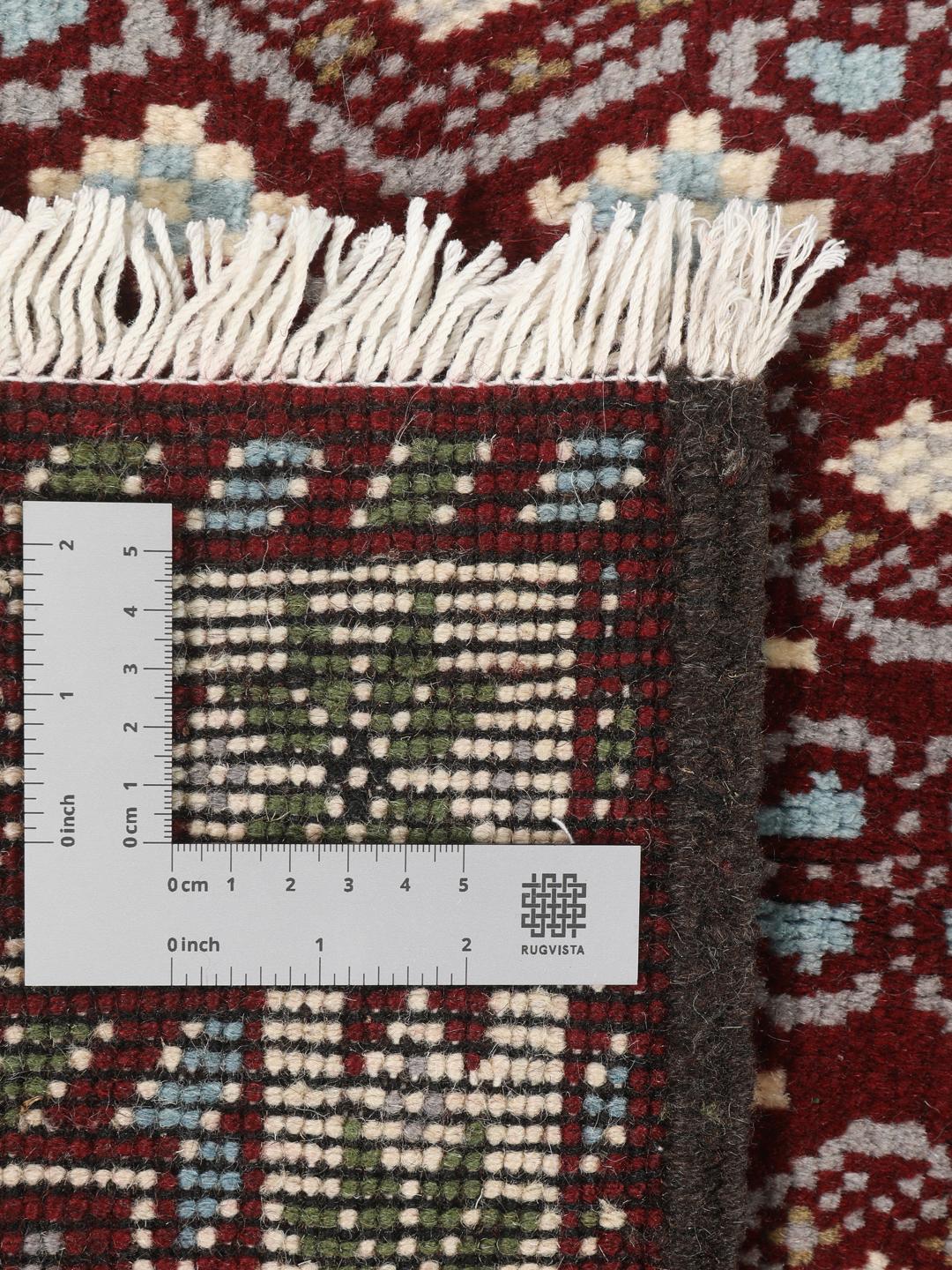Hand-knotted Beluch rug with geometric motifs in red, blue, and cream