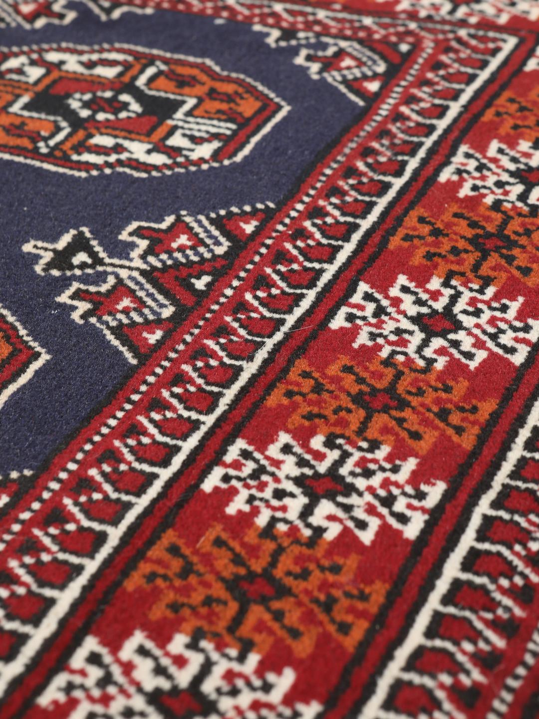 Hand-knotted Turkaman rug from the Middle East in dark-red and dark-blue tones.