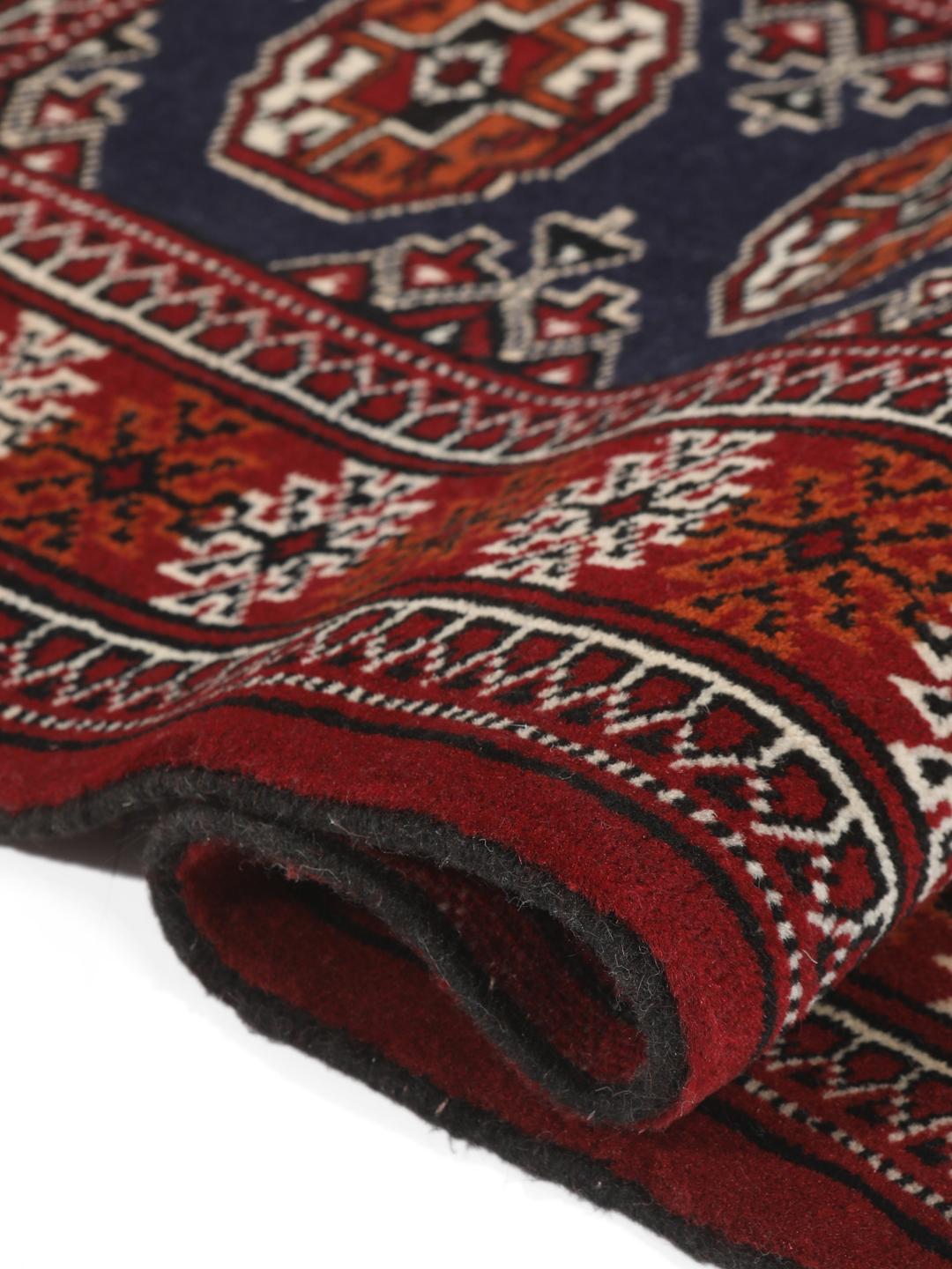 Hand-knotted Turkaman rug from the Middle East in dark-red and dark-blue tones.