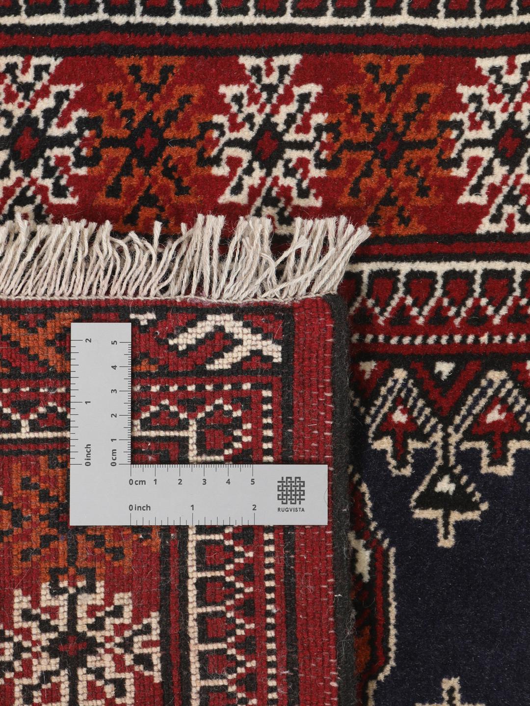 Hand-knotted Turkaman rug from the Middle East in dark-red and dark-blue tones.