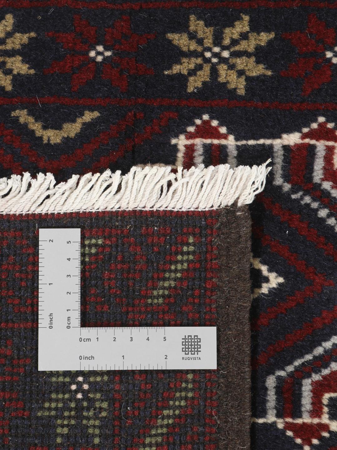 Et håndknyttet Baluch-tæppe fra Mellemøsten med et mørkerødt og blåt geometrisk design.