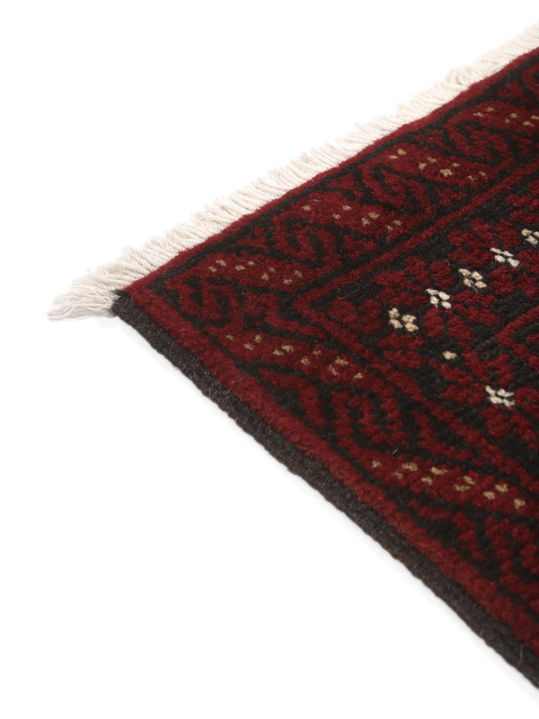 Ein handgeknüpfter Beluch-Teppich mit dunkelrotem und schwarzem Feld aus dem Nahen Osten.