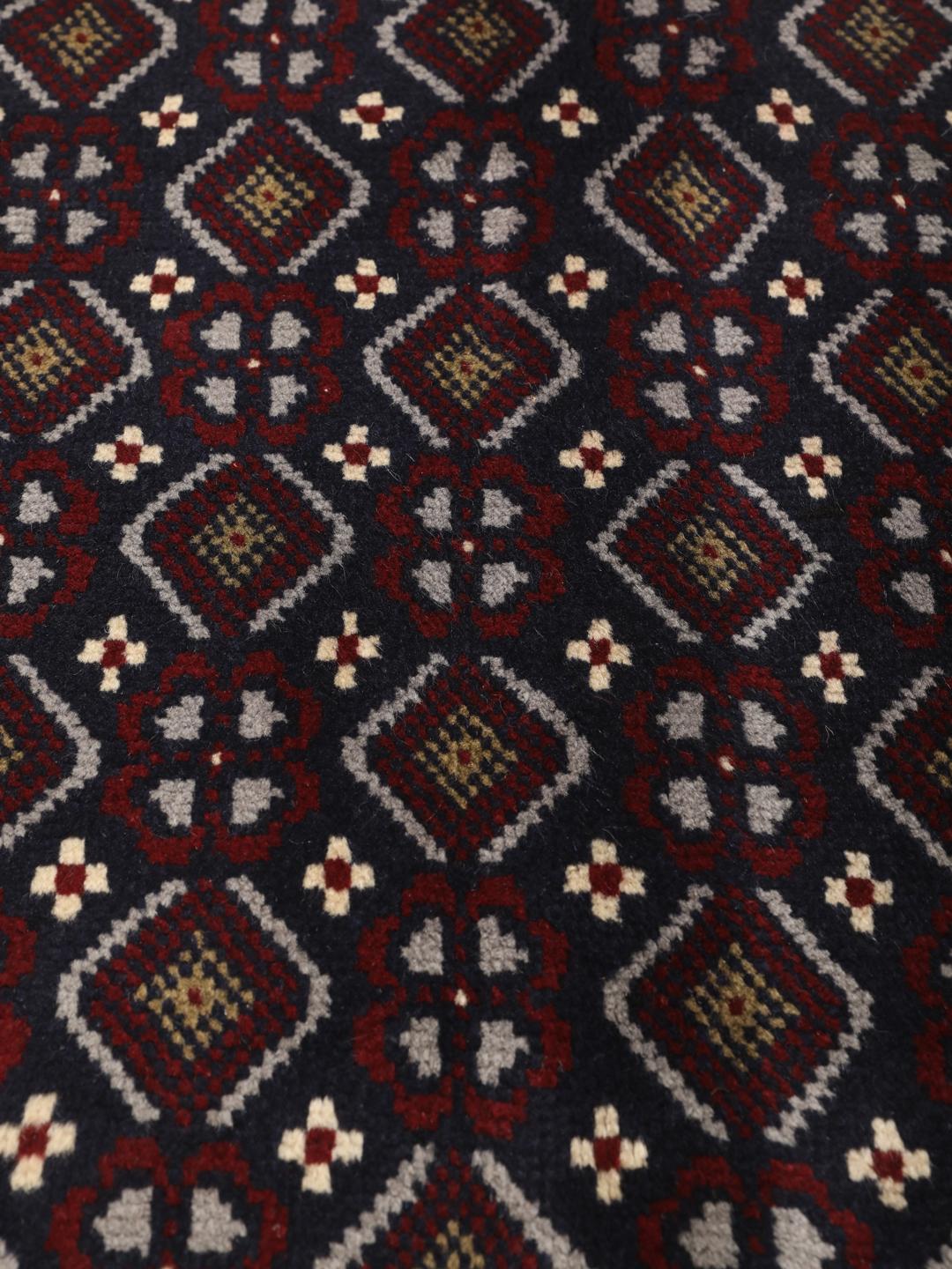 Hand-knotted Baluch rug with geometric motifs in dark-blue and red from the Middle East