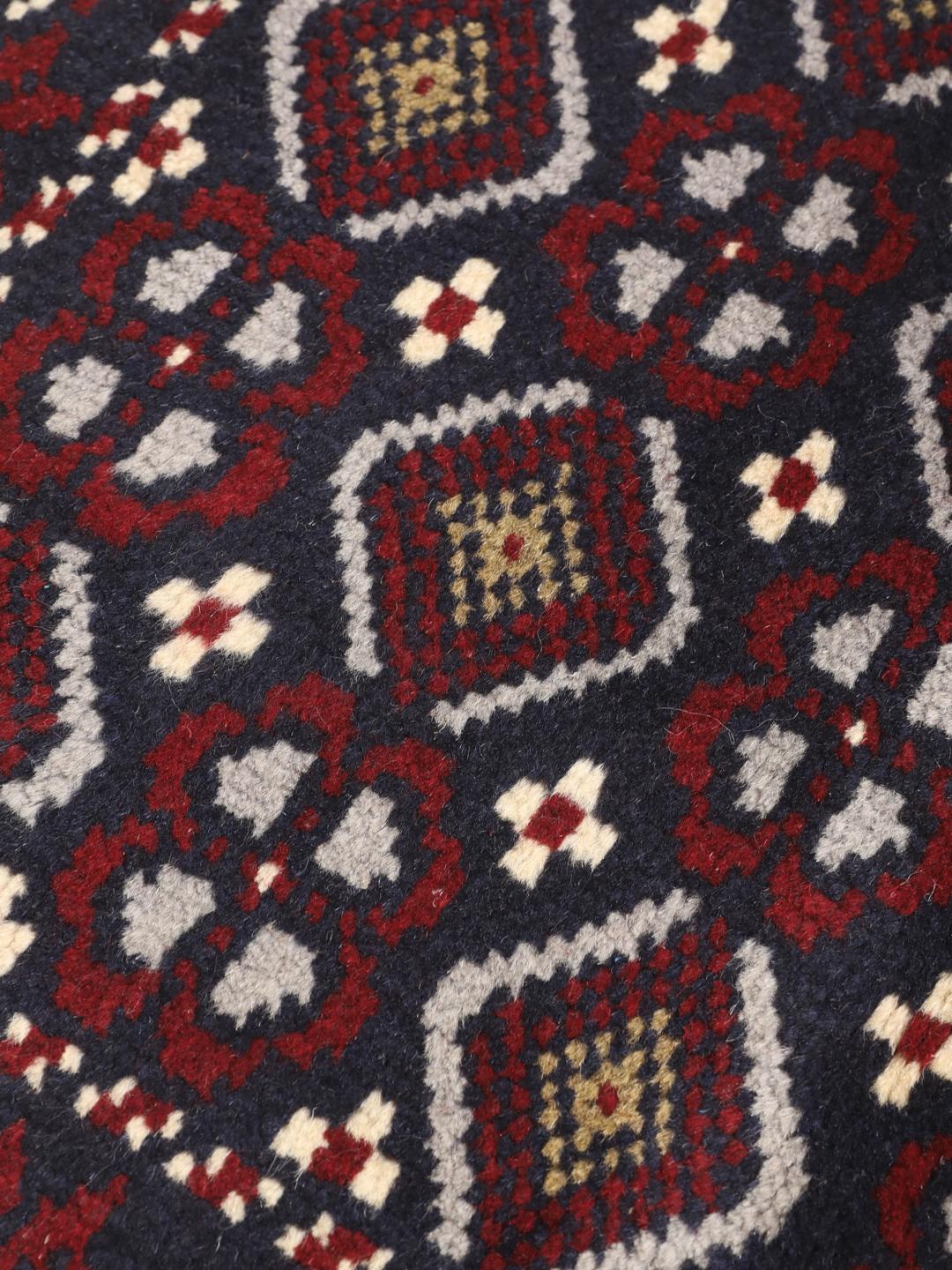 Hand-knotted Baluch rug with geometric motifs in dark-blue and red from the Middle East
