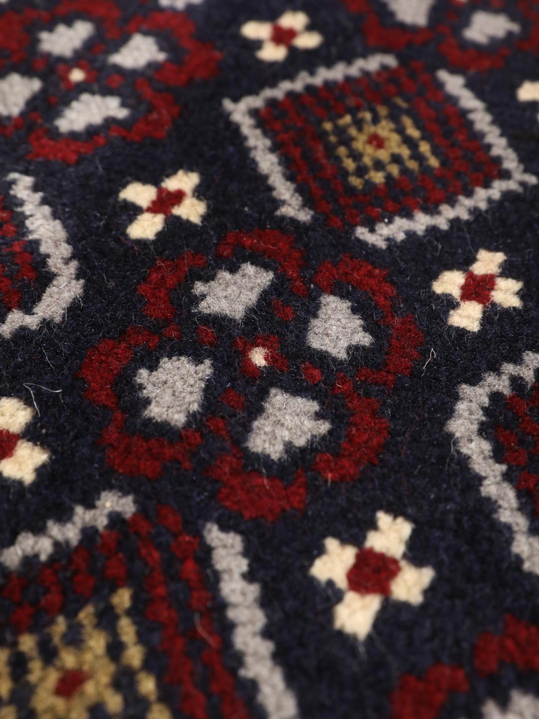 Hand-knotted Baluch rug with geometric motifs in dark-blue and red from the Middle East