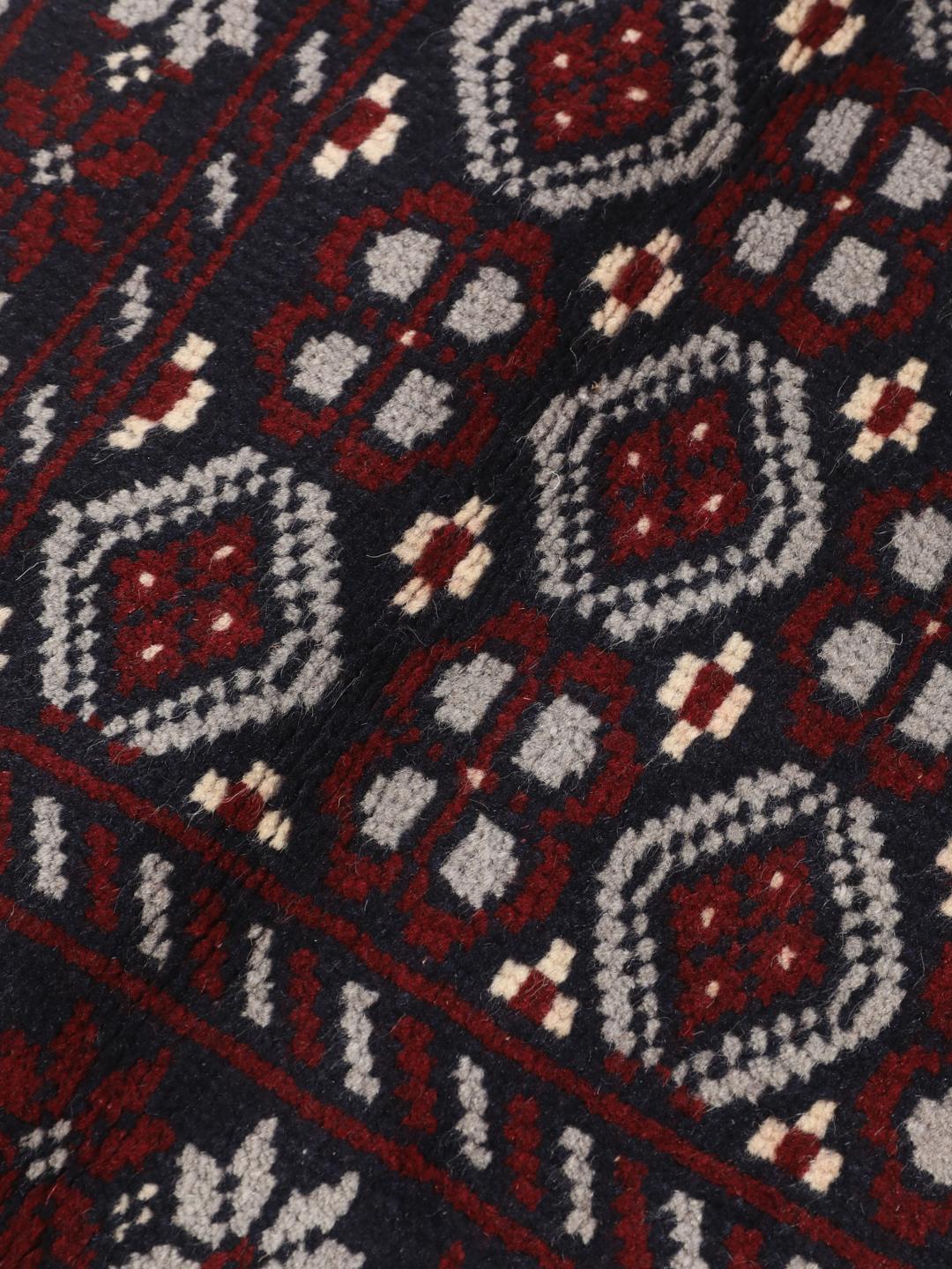 Hand-knotted Baluch rug with geometric tribal patterns in dark blue and red
