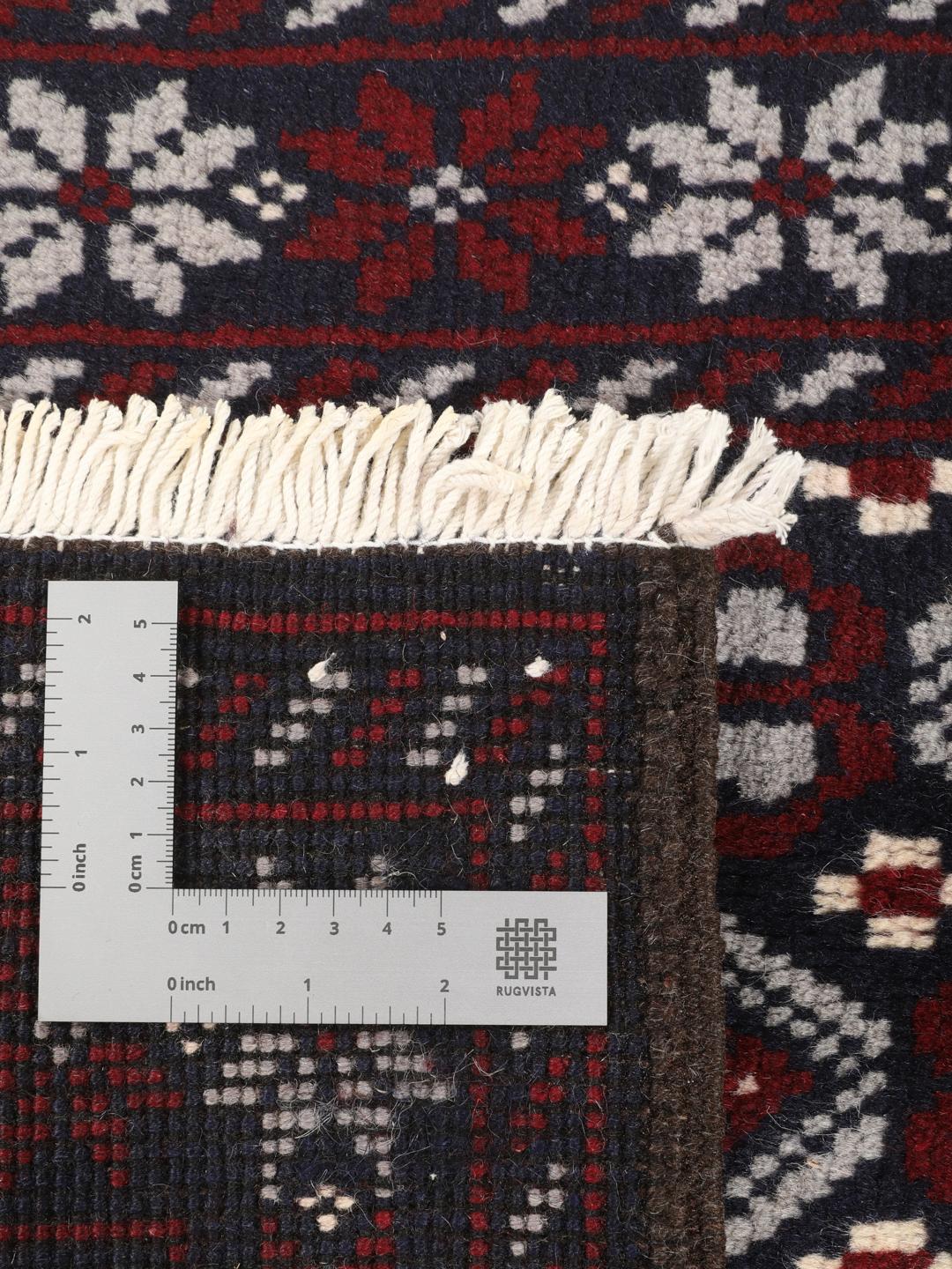 Hand-knotted Baluch rug with geometric tribal patterns in dark blue and red