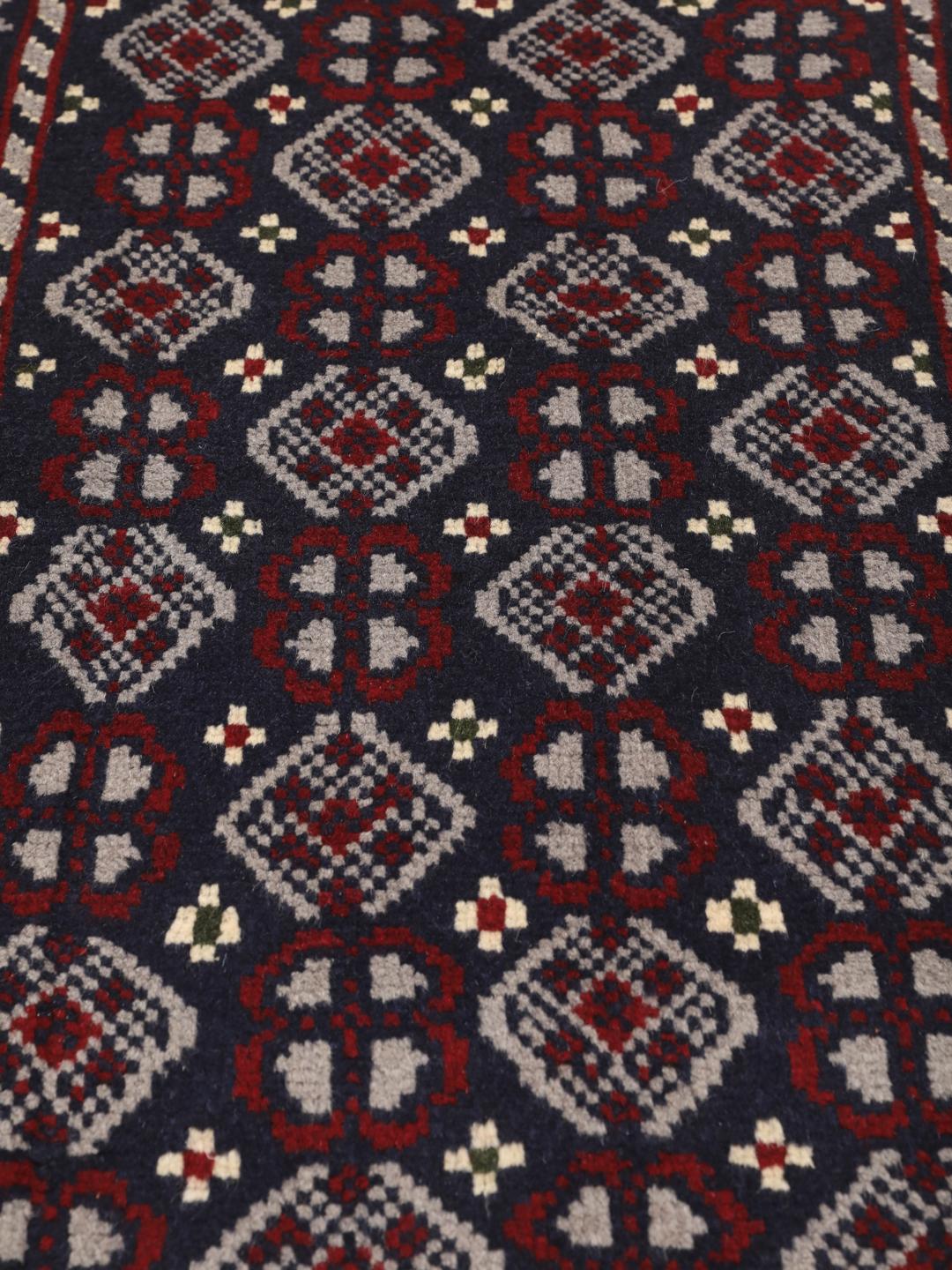 Handmade Baluch rug from the Middle East in dark-blue and dark-red tones.